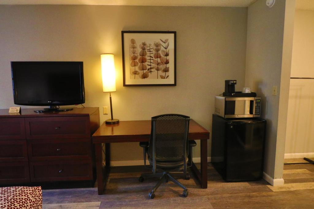 a hotel room with a desk with a television and a microwave at Alpine Village Inn in Helen