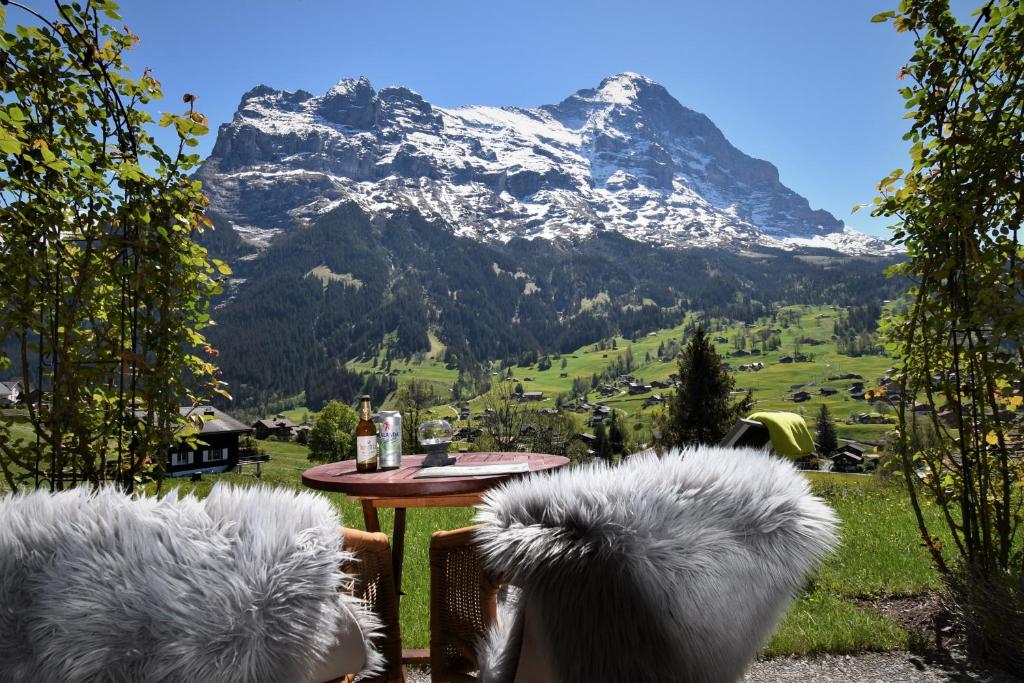 uma mesa com cadeiras e vista para uma montanha em Hotel Cabana em Grindelwald