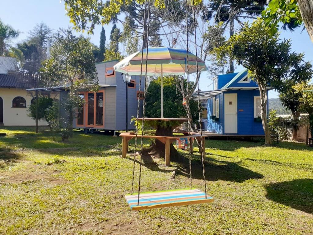 um baloiço num quintal com uma casa em Mini House Park em Campo Alegre