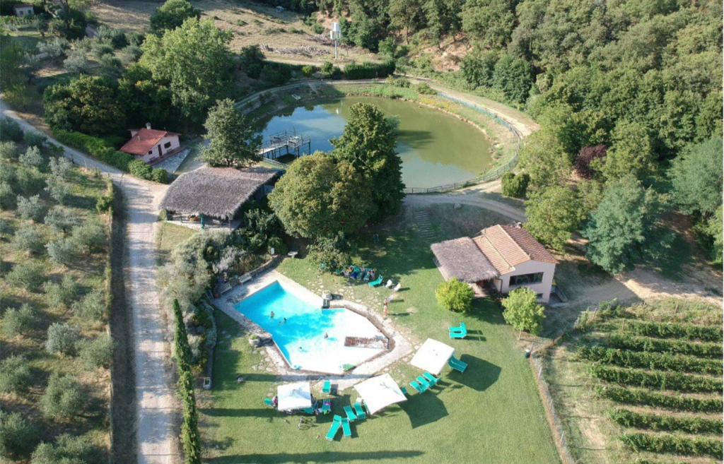 an aerial view of a house with a pool and a lake at Agriturismo Fattoria Celle in Figline Valdarno