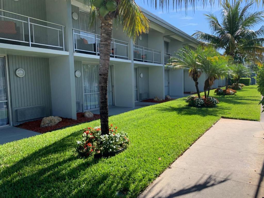 un edificio con palmeras y flores en un patio en The Hollywood Gateway Inn, en Hollywood