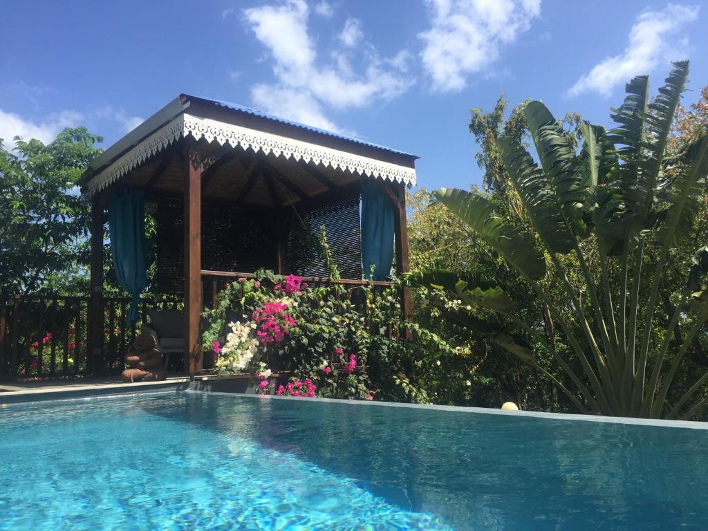 - une piscine en face d'un kiosque dans l'établissement BUNGALOW La Tortue Bleue, à Bouillante