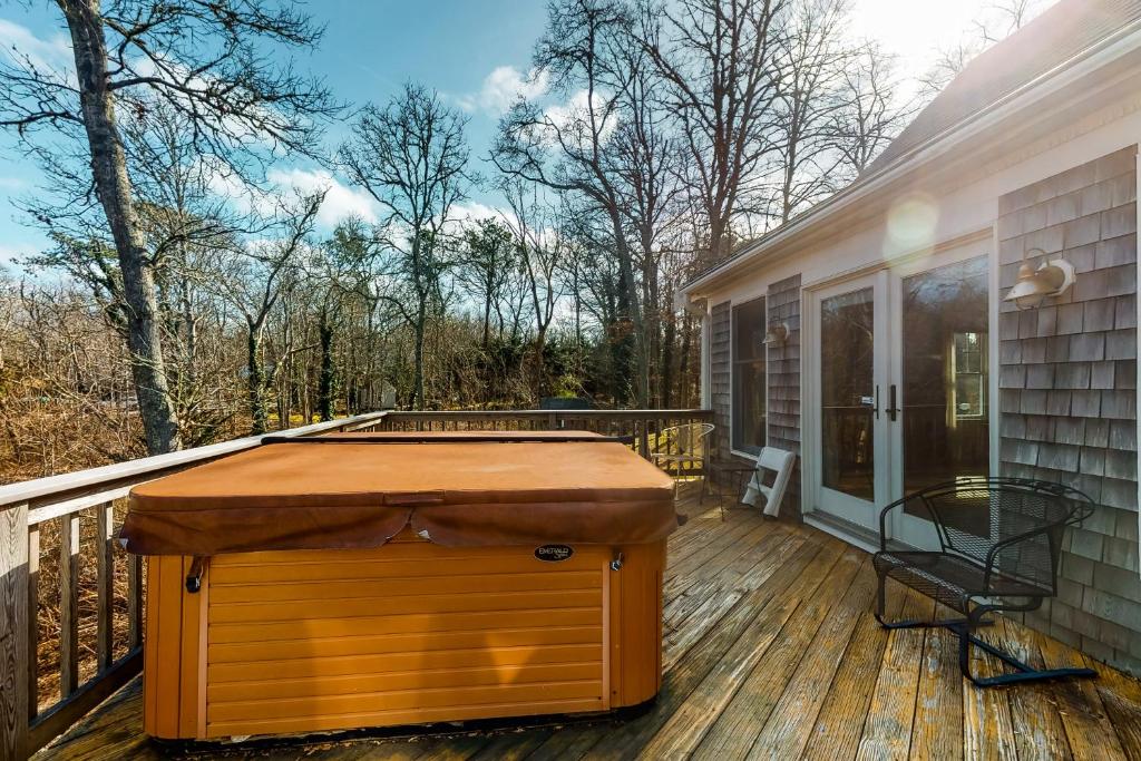 eine Holzterrasse mit einem Tisch auf einem Haus in der Unterkunft Paradise On Cape Cod in Orleans