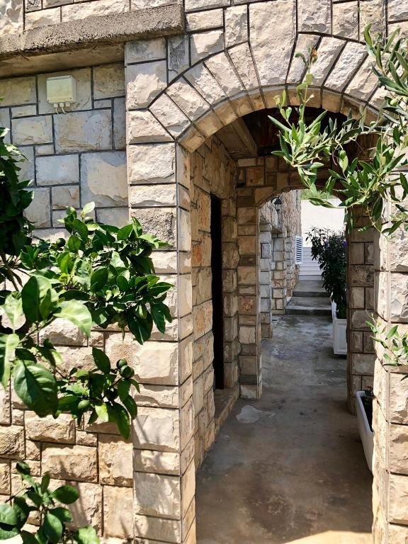 an archway in a stone building with plants at Villa Šolta in Rogač