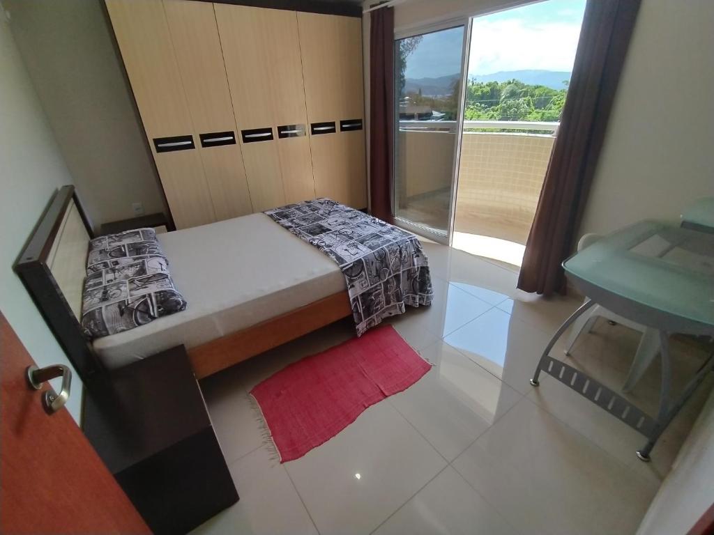 a small bedroom with a bed and a window at Edificio Freitas in Imbituba