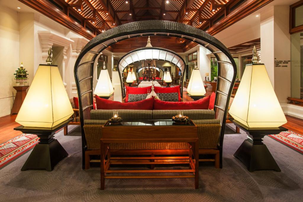 A richly decorated lounge with a mirrored seating alcove and oversized lamps.