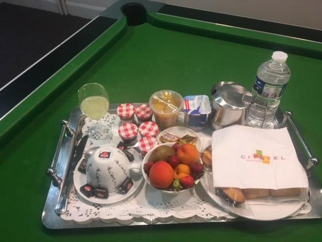 ein Tablett mit Essen auf einem Billardtisch mit Obst in der Unterkunft Cit'Hotel Les Alizés in Limoges