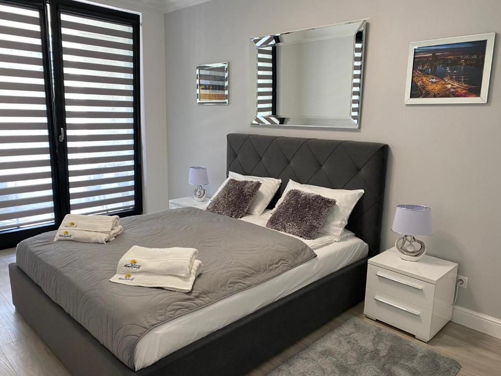 a bedroom with a large bed and a mirror at Apartament Daria Portova in Gdynia