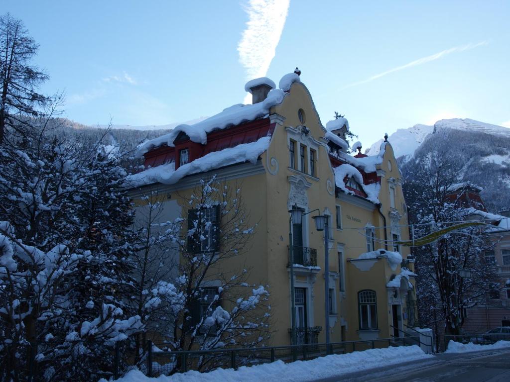 ein gelbes Gebäude mit Schnee drauf. in der Unterkunft Villa Karlstein in Bad Gastein