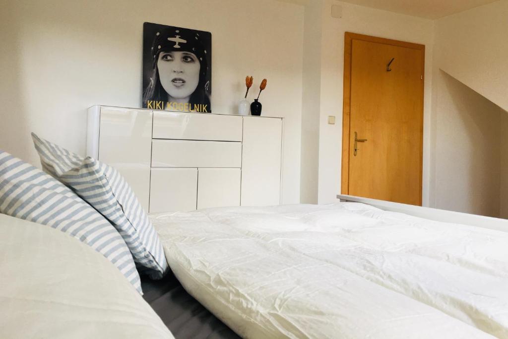 - une chambre avec un lit blanc et une photo d'une femme dans l'établissement Ferienhaus am Tor zur Wachau, à Eggendorf
