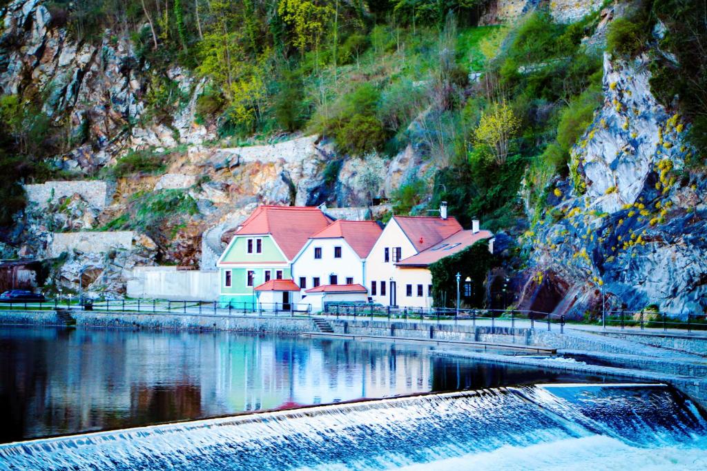 un gran edificio blanco con techos rojos junto al agua en Pension Labyrint, en Český Krumlov
