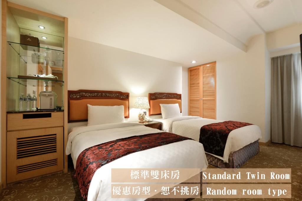 a hotel room with two beds and a mirror at Hotel Sunshine in Kaohsiung