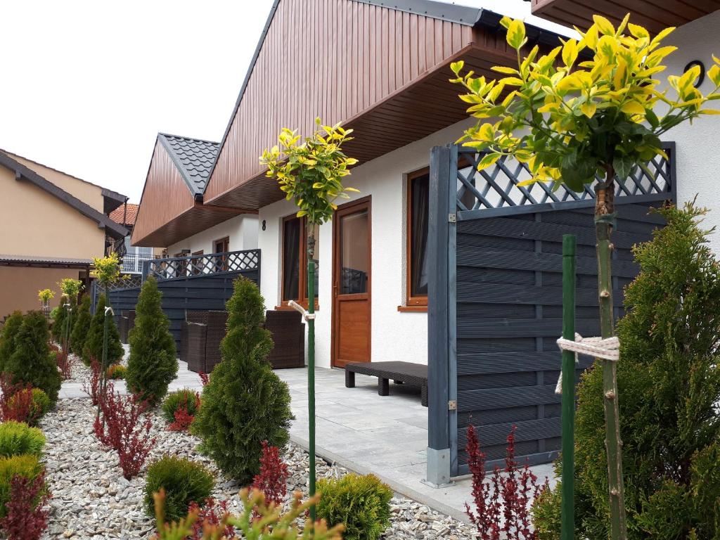 a house with a blue fence and a garden at Flaming - domki letniskowe in Rowy