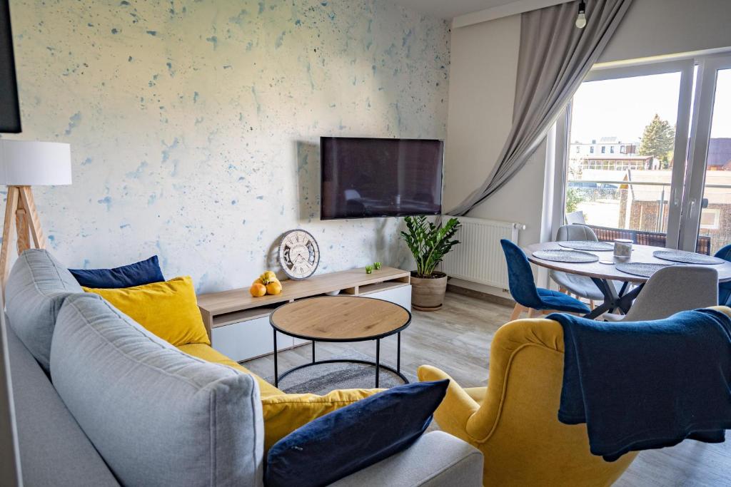 a living room with a couch and a tv at Apartament Victoria 5 Mórz in Sianozety