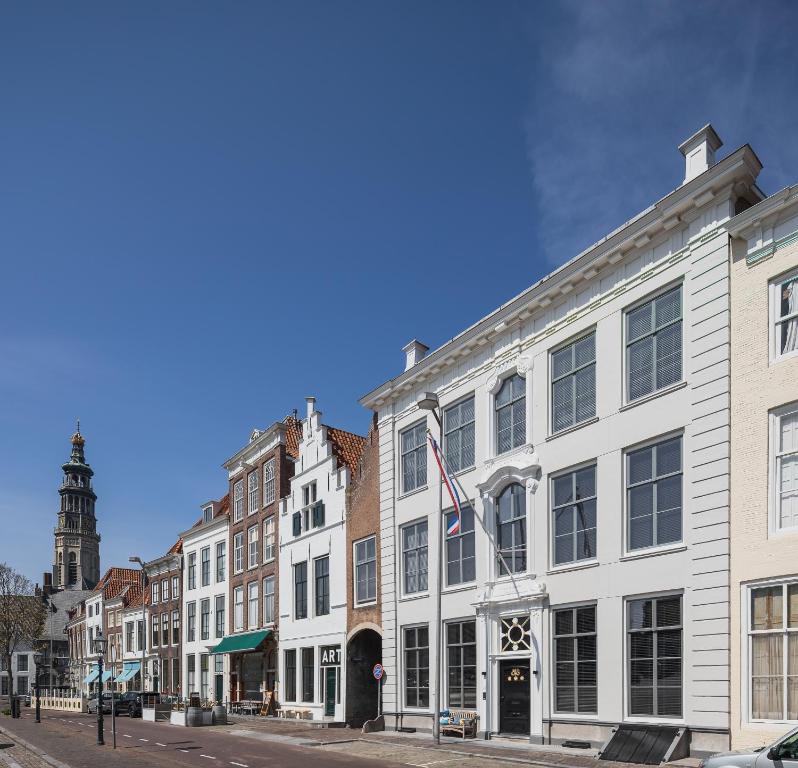 a row of white buildings on a city street at Boutique Hotel De Vier Patriciërs in Middelburg