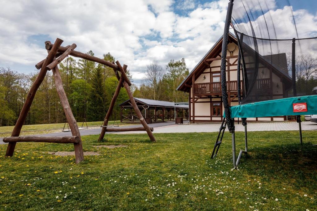 un'altalena in un parco con un edificio di Farma Hory a Karlovy Vary