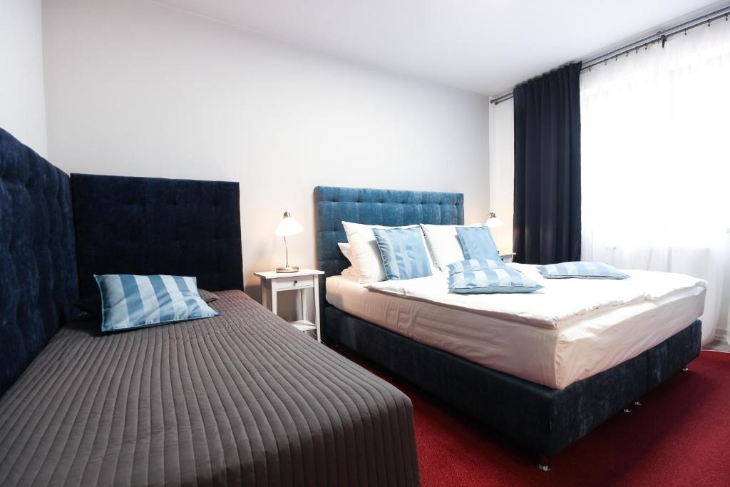 ミクロフにあるホテル マロリ ミクロフのベッドルーム1室(青い枕のベッド2台付)