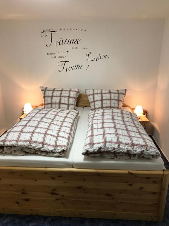 1 cama con 2 almohadas y un cartel en la pared en Cozy Braunlage en Braunlage