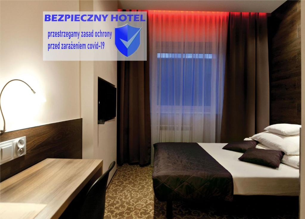 Pokój hotelowy z łóżkiem i biurkiem w obiekcie Nu Hotel w Łodzi