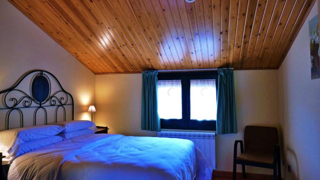 1 dormitorio con cama y techo de madera en Cal Crispi, en Prades