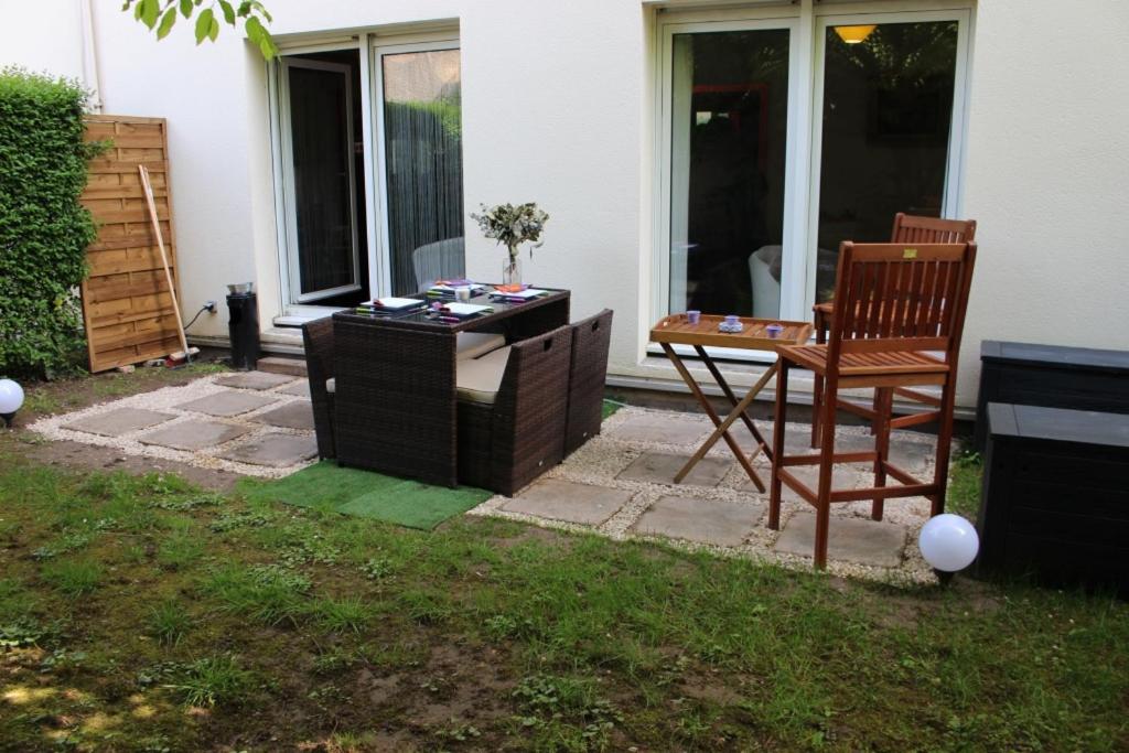a patio with a table and a chair in the yard at Le Garden Victoria - Canal & Cathédrale -30m2 & Garden in Nancy