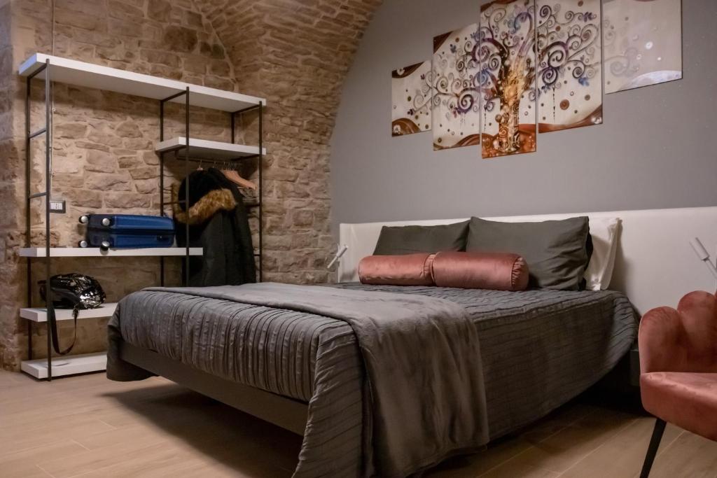 - une chambre avec un lit et un mur en pierre dans l'établissement Suite 123 Luxury B&B Con Jacuzzi, à Palo del Colle