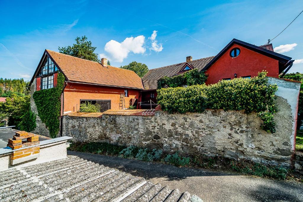 dom z kamienną ścianą i czerwonym domem w obiekcie Rusty's Cottage w mieście Sedlčany