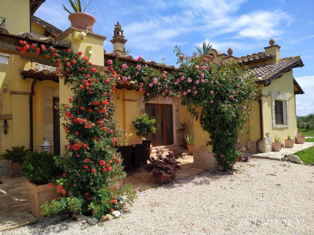 a house with flowers in front of it at Casale Di Vulci in Case Riminino