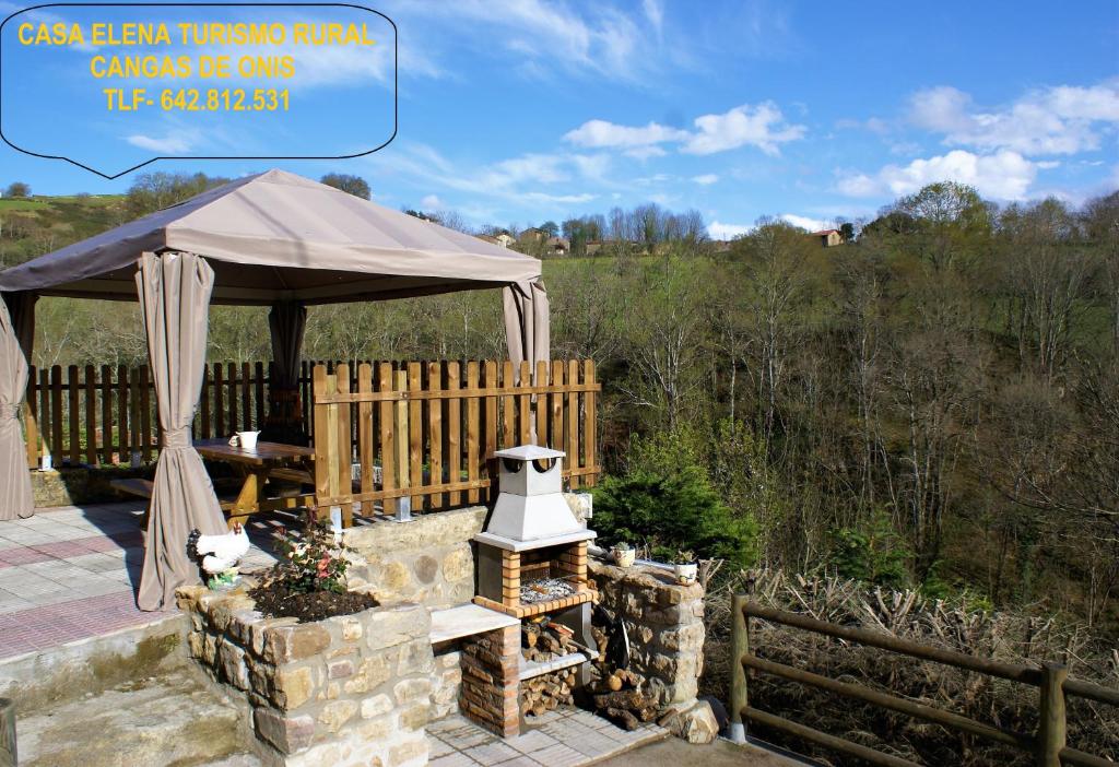 a gazebo with a fireplace in a yard at Casa Elena Cangas de Onis con WiFi y parking gratuito in Cangas de Onís