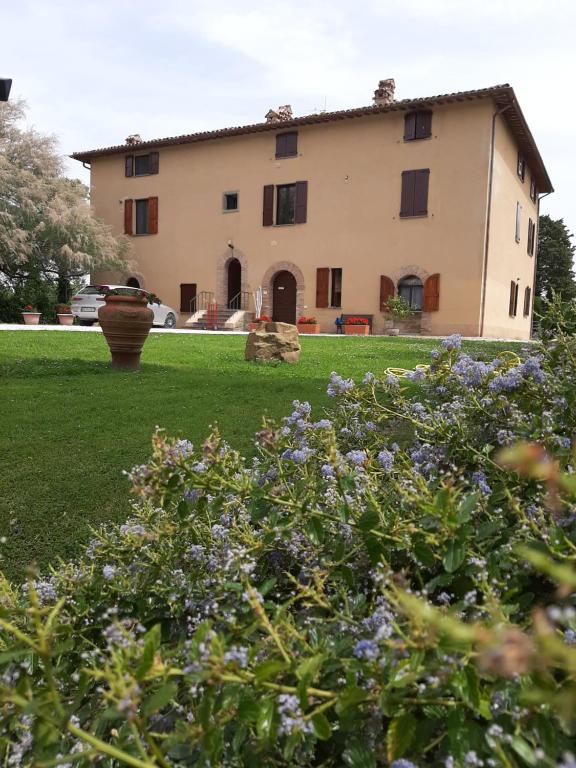 una casa grande frente a un patio con flores en Villa Finetti, en Gubbio