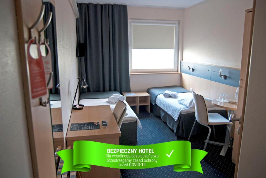 um quarto de hotel com uma cama e uma mesa em Economy Silesian Hotel em Katowice
