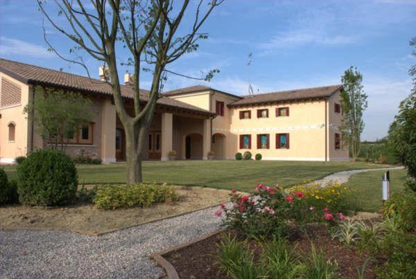 une grande maison avec un arbre en face dans l'établissement Agriturismo alle Rose, à Ca Baglioni