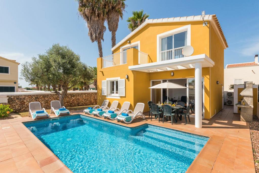 a villa with a swimming pool in front of a house at Samuel y Benjamin in Ciutadella