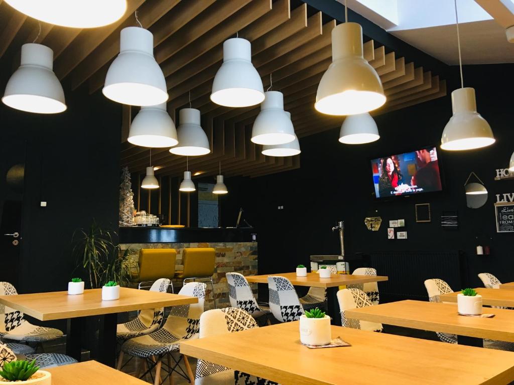 a restaurant with wooden tables and chairs and lights at Pensiunea Morariu in Bistriţa