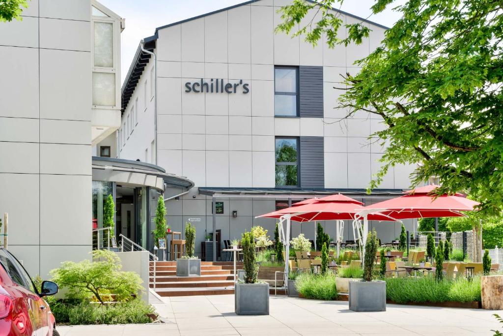 un bâtiment avec des parapluies devant lui dans l'établissement Hotel Schiller, à Olching