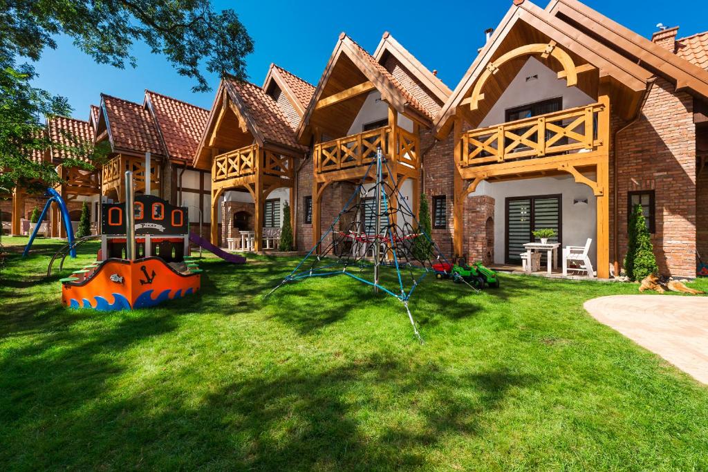 a house with a playground in the yard at Domki Hallerowka Resort in Władysławowo