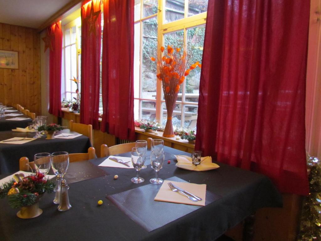 a dining room with two tables with red curtains at Hotel Val Joly in Saint-Gervais-les-Bains