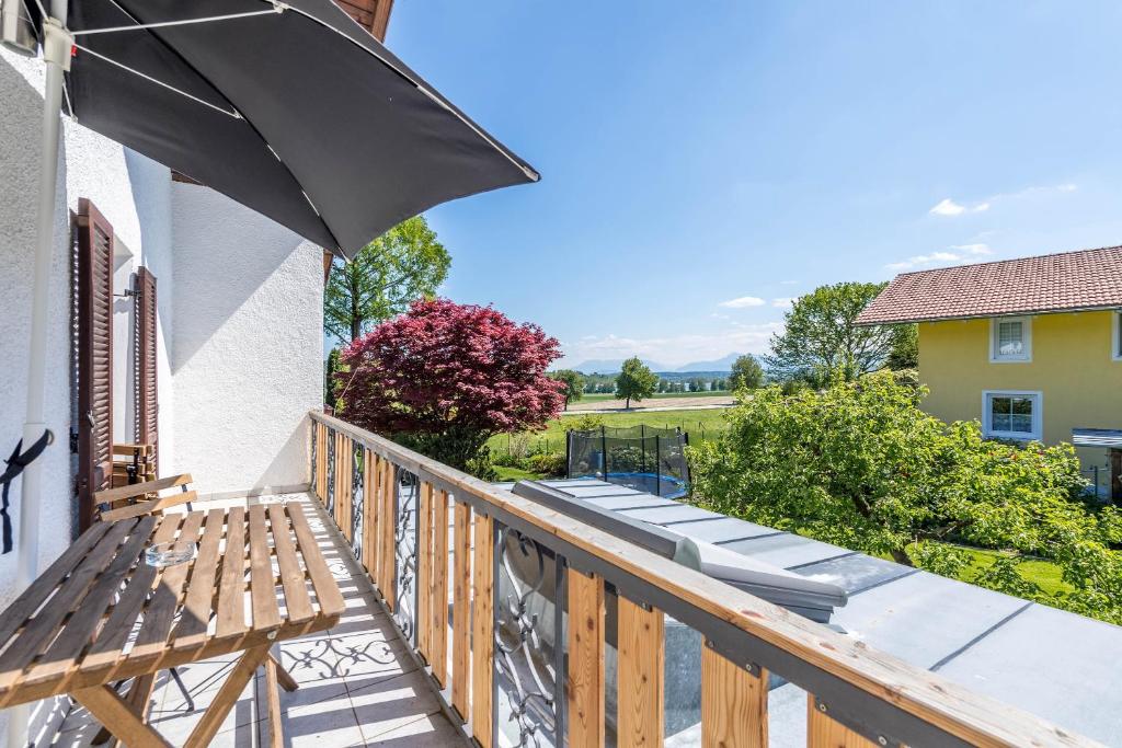 a balcony with a black umbrella and benches at Ferienwohnung Selina in Taching am See