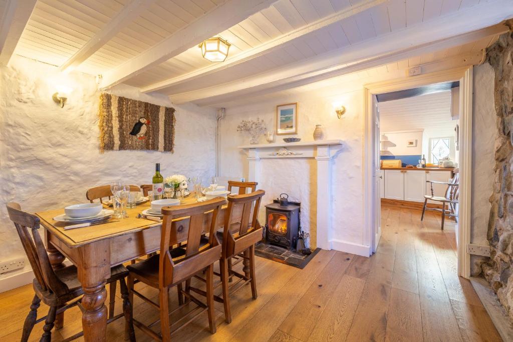 a dining room with a table and a wood stove at Scrumbles Hollow in St. Agnes 