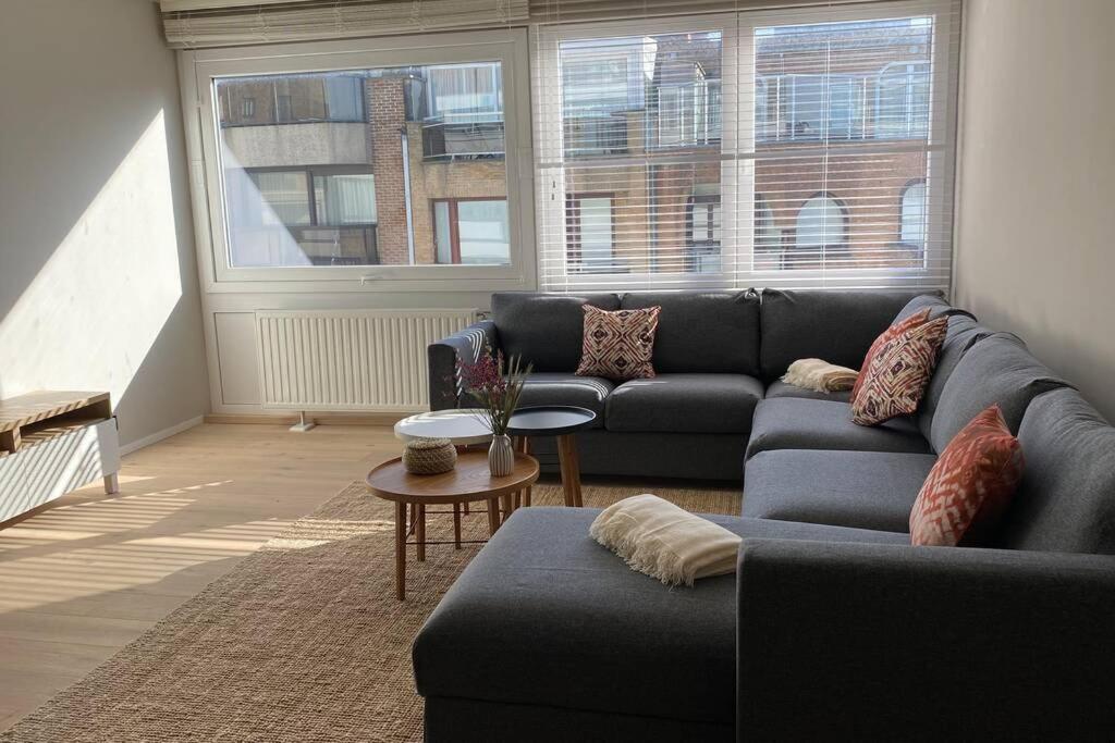 ein Wohnzimmer mit einem Sofa und einem Tisch in der Unterkunft modern appartement near beach in Knokke in Knokke-Heist