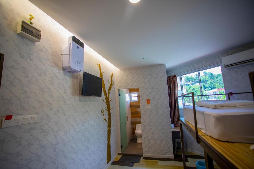 a room with a bunk bed and a bathroom at Lazy Cat Home At Gaya Street in Kota Kinabalu