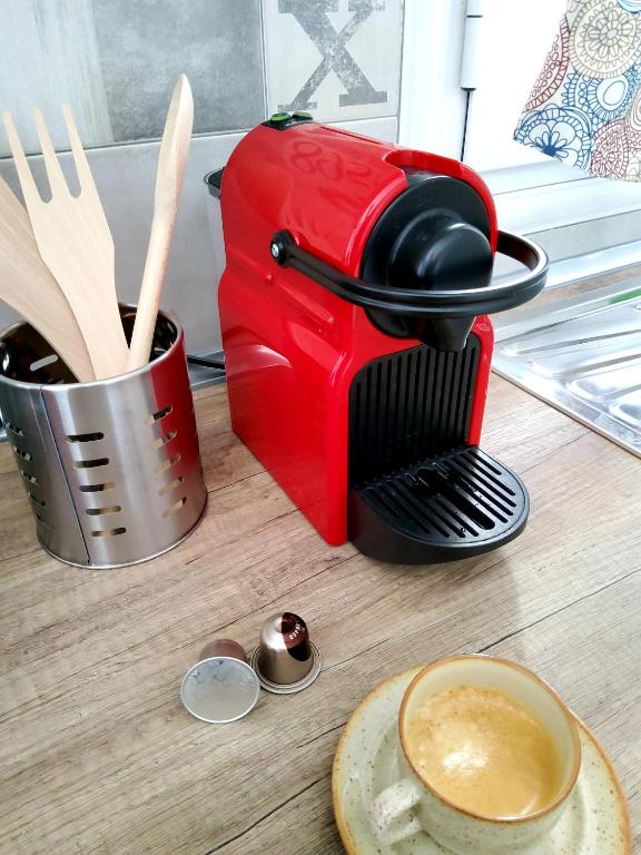 a red coffee maker on a table with a cup of coffee at Nefeli in Livadi