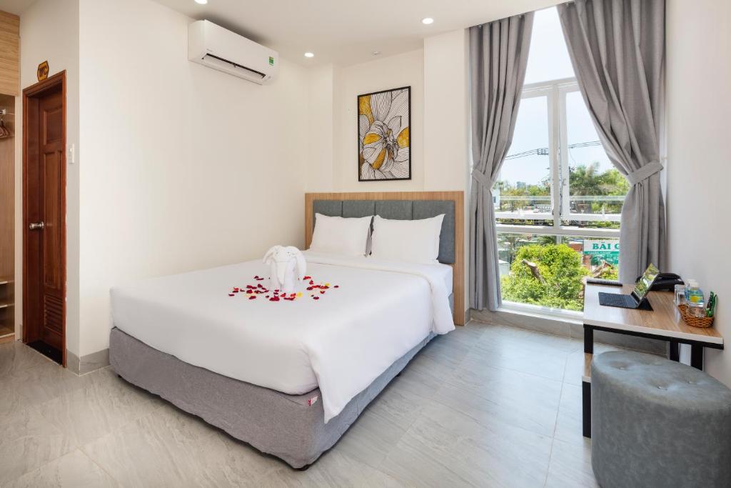 a bedroom with a large white bed and a window at SALAH HOTEL in Quy Nhon