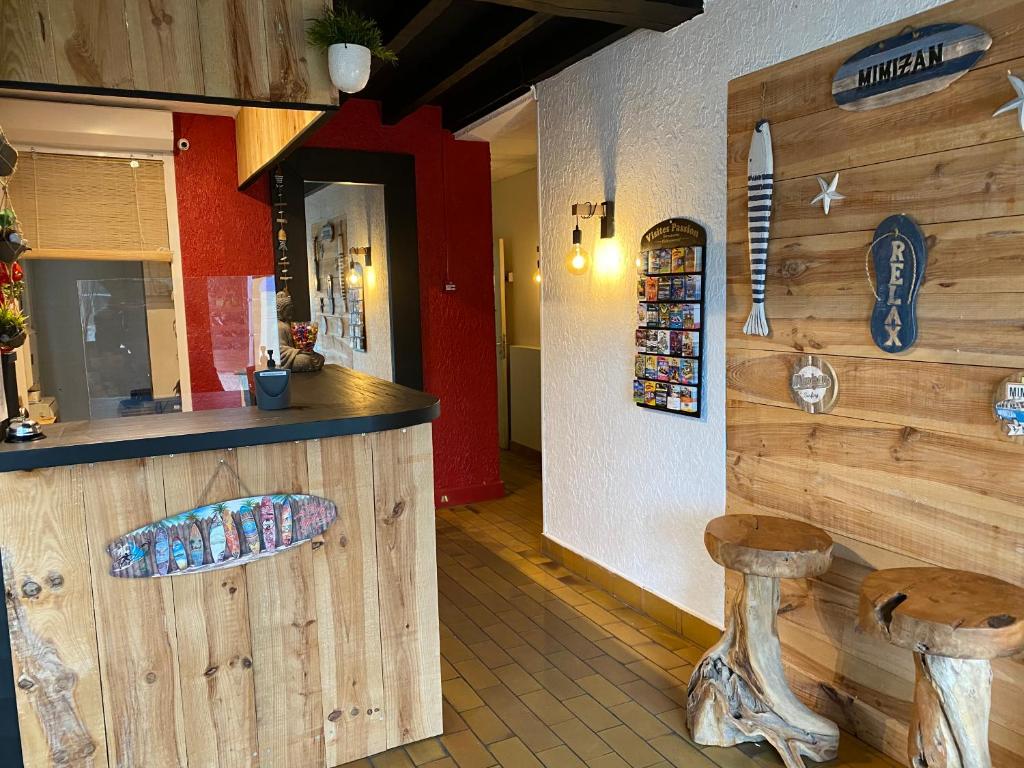 a restaurant with a counter with two wooden stools at Hôtel Bellevue in Mimizan-Plage