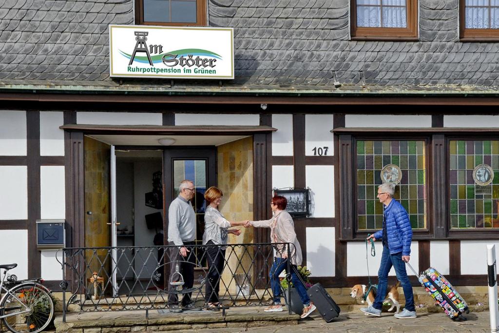 een groep mensen die een gebouw uitlopen bij Ruhrpottpension Am Stöter in Witten