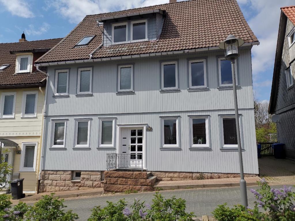 une maison blanche avec un toit marron dans l'établissement Großes schönes Ferienhaus mit Garten für 12 Personen erwartet Sie im Harz!, à Sankt-Andreasberg