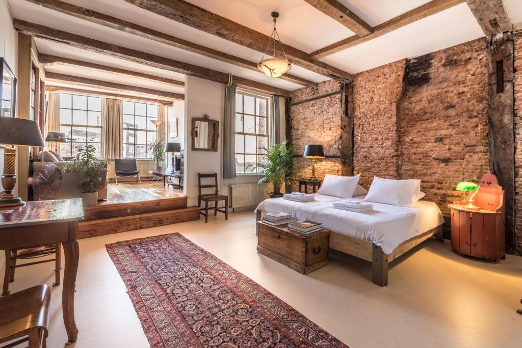 a bedroom with a bed and a brick wall at Classy Room 17th C Canalhouse in Amsterdam