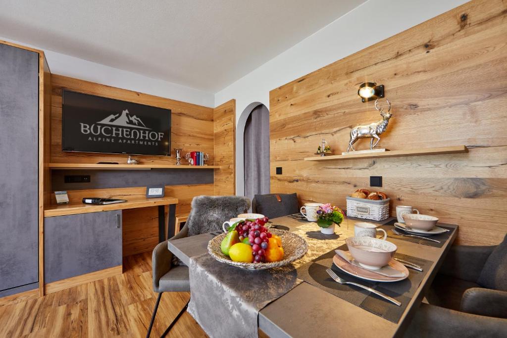 a dining room with a table with a bowl of fruit on it at Gästehaus Buchenhof in Grainau