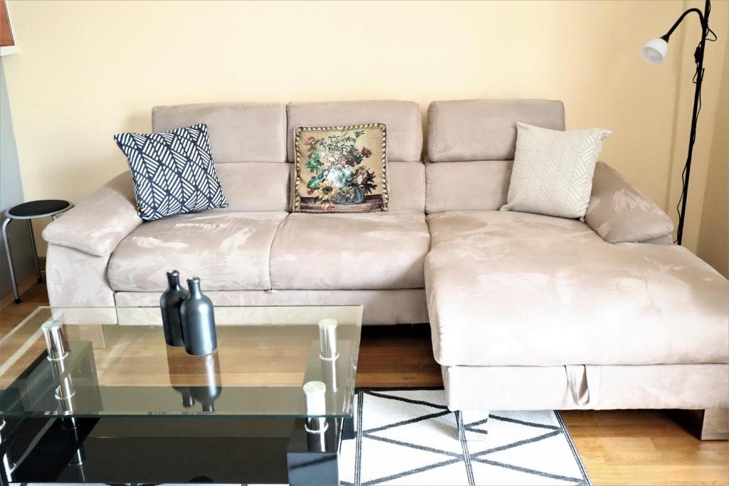 ein Wohnzimmer mit einer Couch und einem Glastisch in der Unterkunft Apartment Fox in Karlsbad