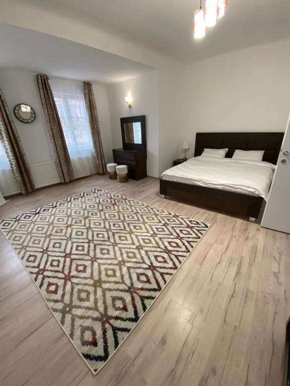 a bedroom with a bed and a rug on the floor at CentralHome Ap1 in Sighişoara